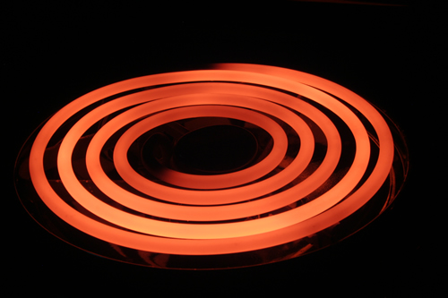 This is an image of an electric stove coil that is glowing red because it is hot.