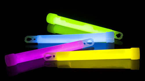 This is an image of four coloured glow sticks that are shining green, blue, purple and yellow.